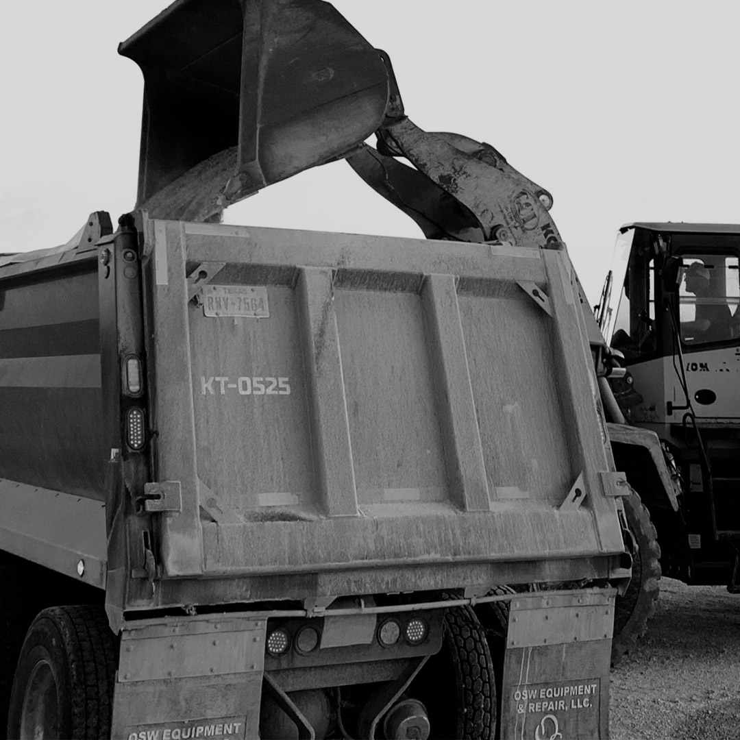 black and white view of a dump truck being loaded with haul-off aggregate